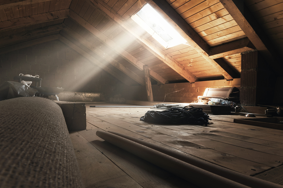 Dusty open attic with sunbeams coming in through a window.