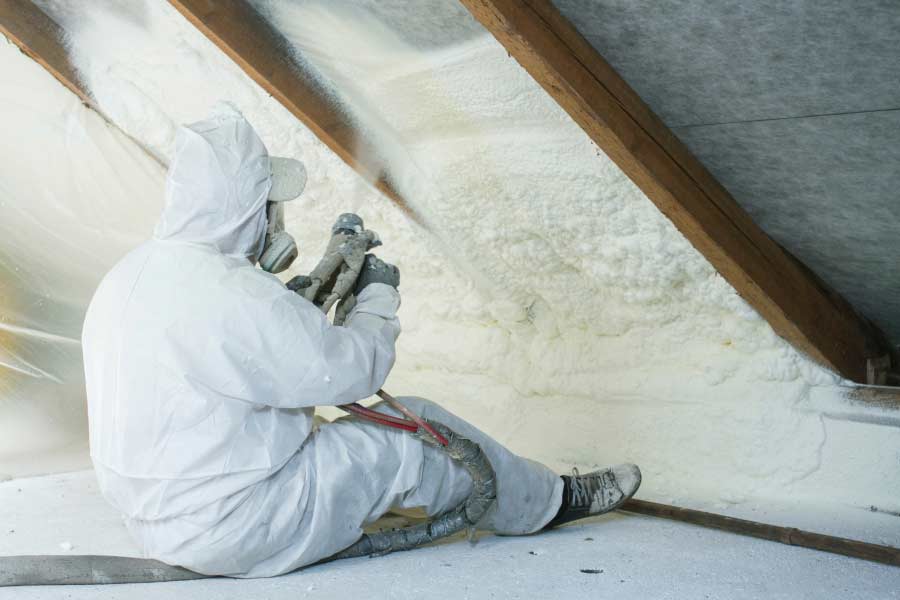 Spray foam insulation installer insulating attic's ceiling.