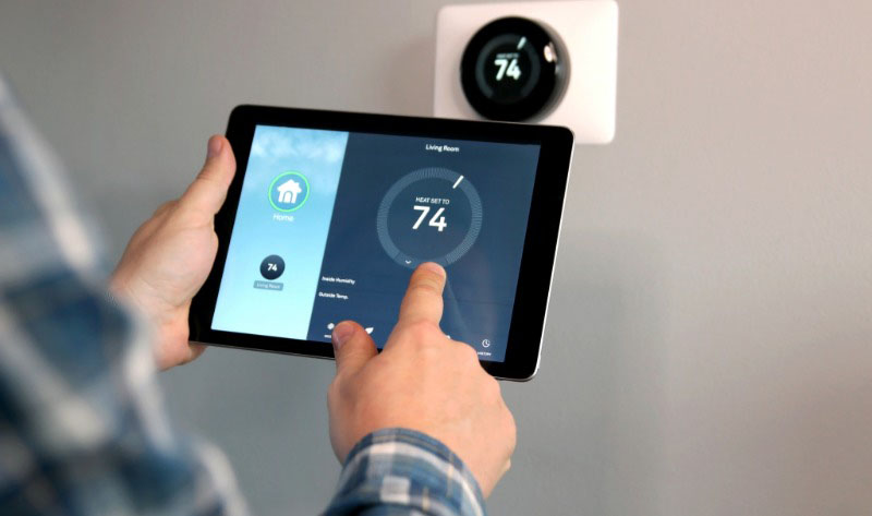 Upclose image of a man's hand adjusting the settings on hiss. smart thermostat app.