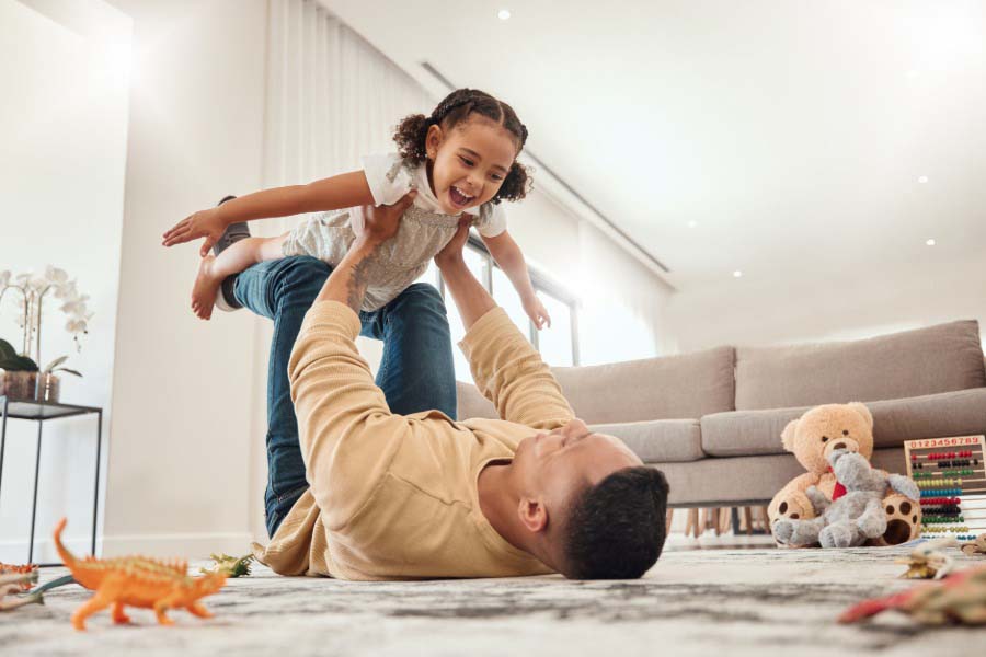 Happy family, father and girl playing in a house with freedom, bonding and enjoying quality time together.