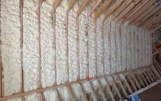 Close-up of open-cell spray foam insulation filling rafter bays. Close-up of open-cell spray foam insulation filling rafter bays along a sloped attic roof in a Nashville home.