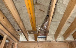 Open-cell spray foam insulation on angled roofline with HVAC duct run and ridge beam, luxury custom home in Mt. Juliet, TN — Hayes Insulation Nashville.