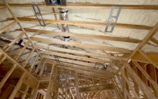 Open-cell spray foam ceiling insulation with HVAC duct boot above hallway framing in custom home, Mt. Juliet, TN, by Hayes Insulation Nashville.