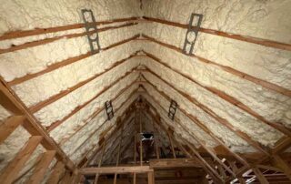 Open-cell spray foam insulation on vaulted roof peak with mounting brackets in luxury custom home, Mt. Juliet, TN — J'adore Luxury Custom Homes, Hayes Insulation Nashville.