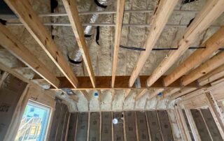 Open-cell spray foam insulation on the roof deck above ceiling joists and a window wall with kraft-faced fiberglass batts, new AJSF Heritage Homes construction, Nashville, TN, by Hayes Insulation Nashville