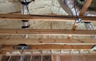 Open-cell spray foam insulation on roof deck with faced fiberglass wall batts below, in a new AJSF Heritage Homes build.