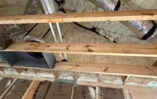 Open-cell spray foam insulation on the roof deck around insulated HVAC flex ducts and plumbing lines, above kraft-faced fiberglass wall batts, in a new AJSF Heritage Homes build, Nashville, TN, by Hayes Insulation Nashville.